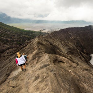 Hikers walking around an active volcano.