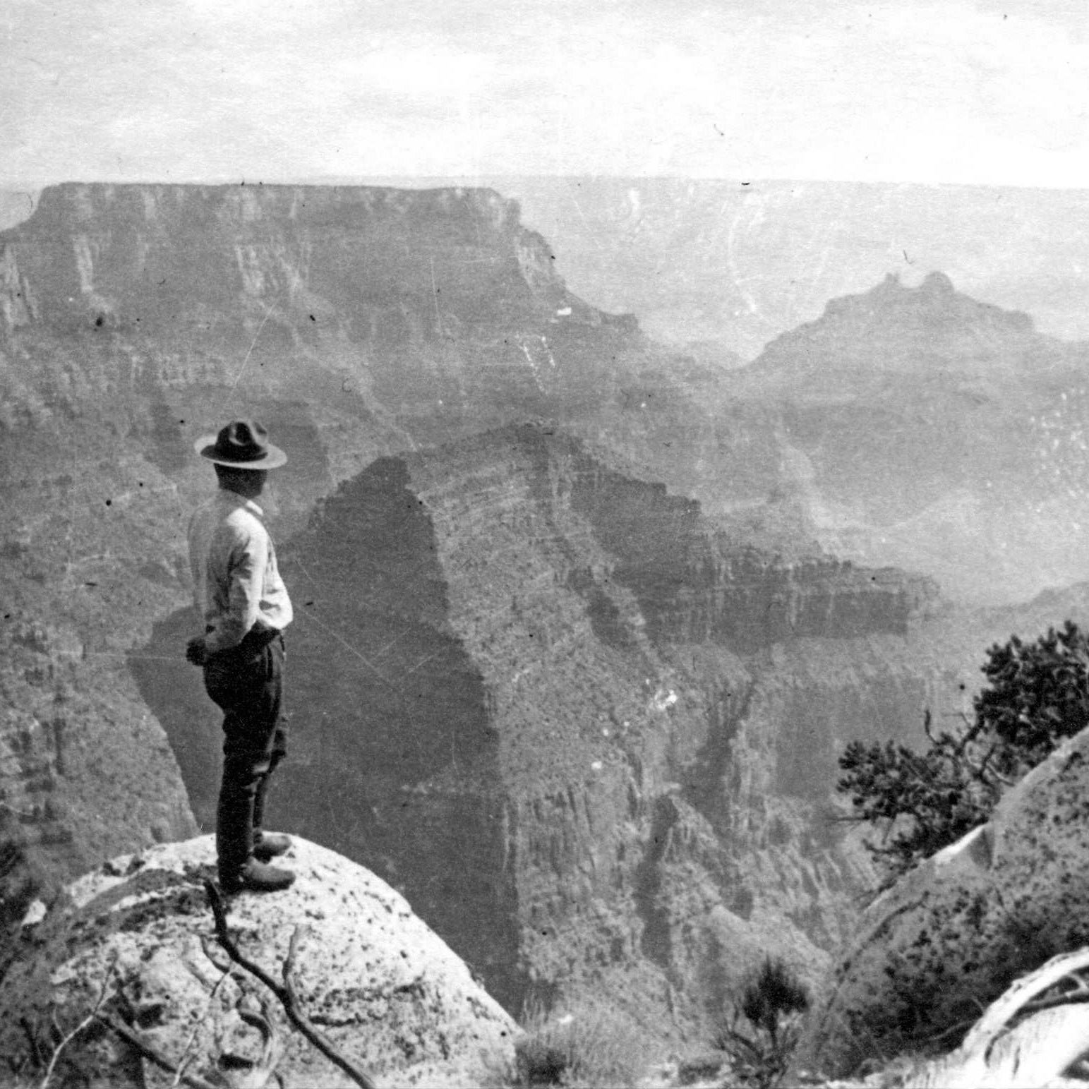 UNIFORMED RANGER TEX WORLEY LOOKS AT CANYON FROM ARAPAHOE POINT, W OF CAPE ROYAL. SEPT 1936. NPS