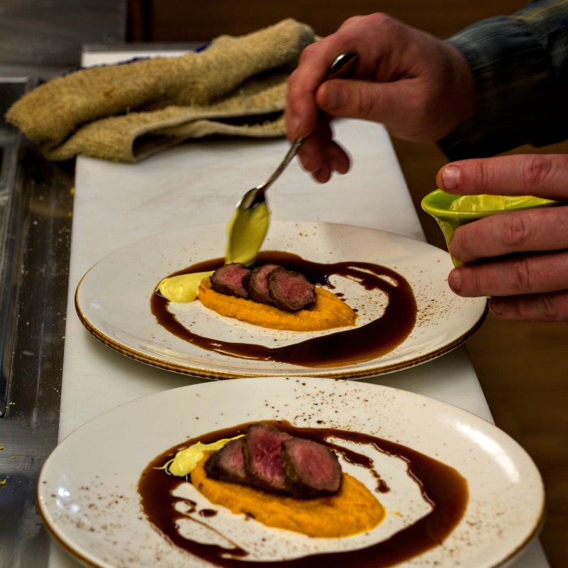 Preparing a chevon dish.