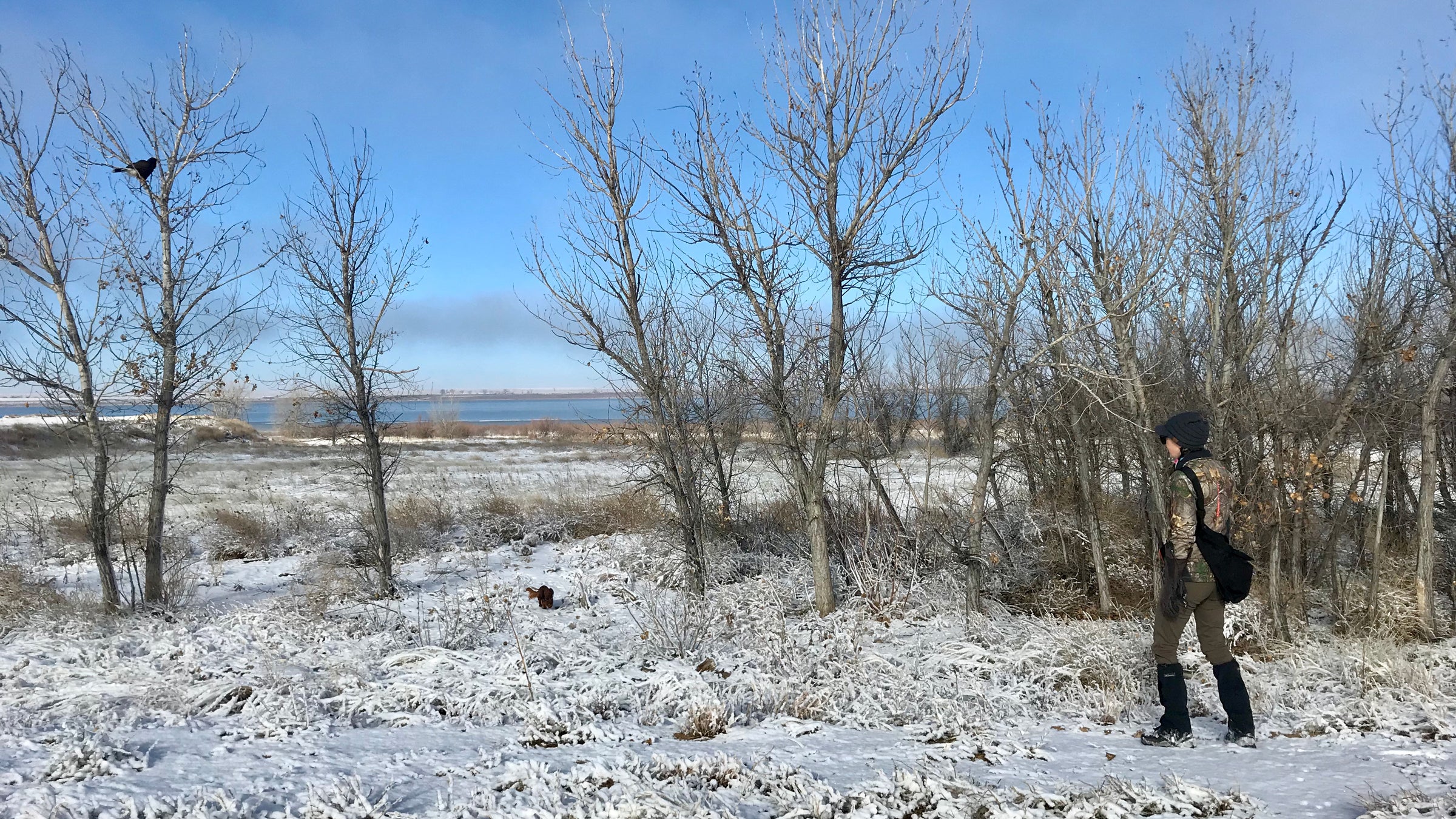 A woman walking in the snow with the Bandolero Hawking Bag.