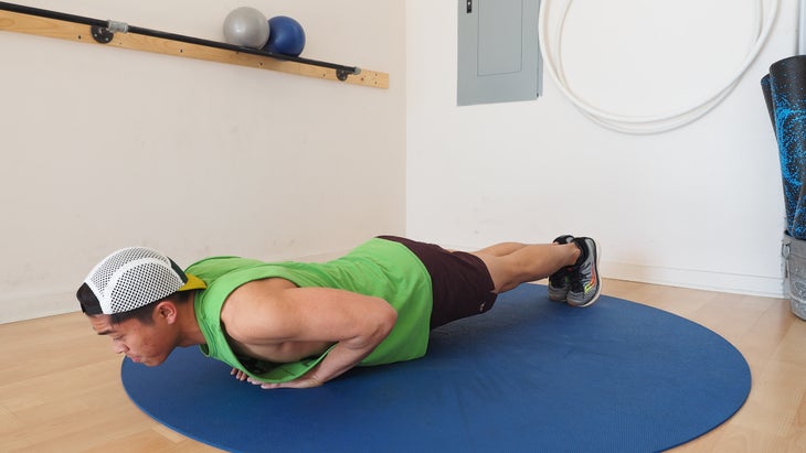 man with arms below him nearly on floor in plank