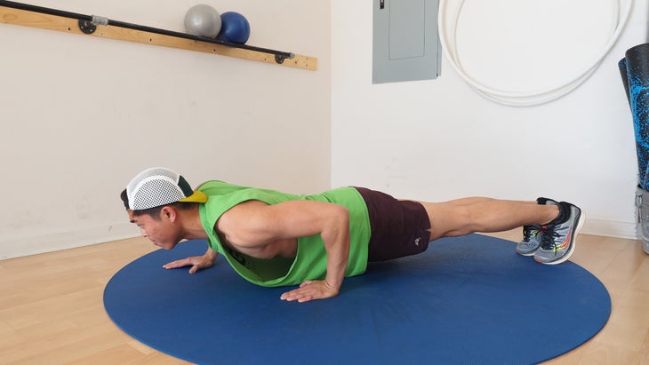 man in low plank in gym