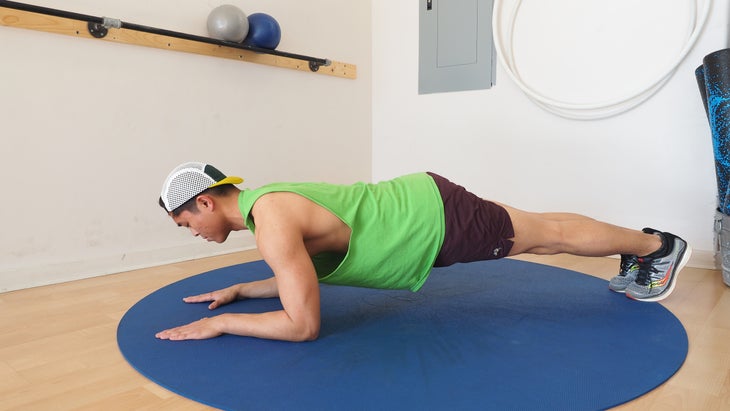 man in gym in elbow plank