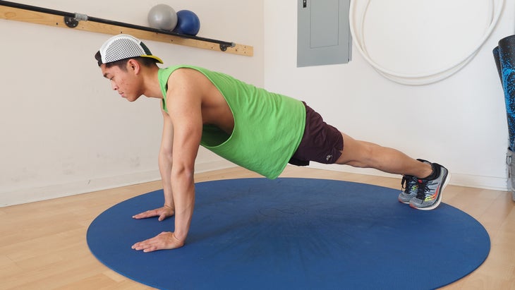 man in green shirt in high plank