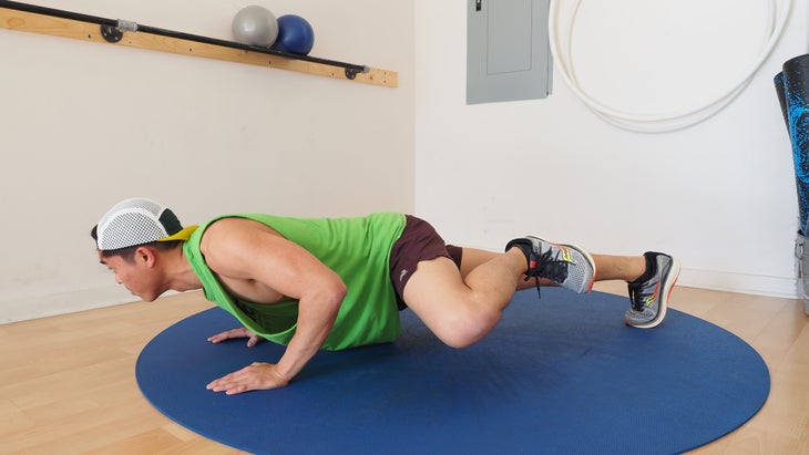 man in low plank working his left knee toward his left elbow