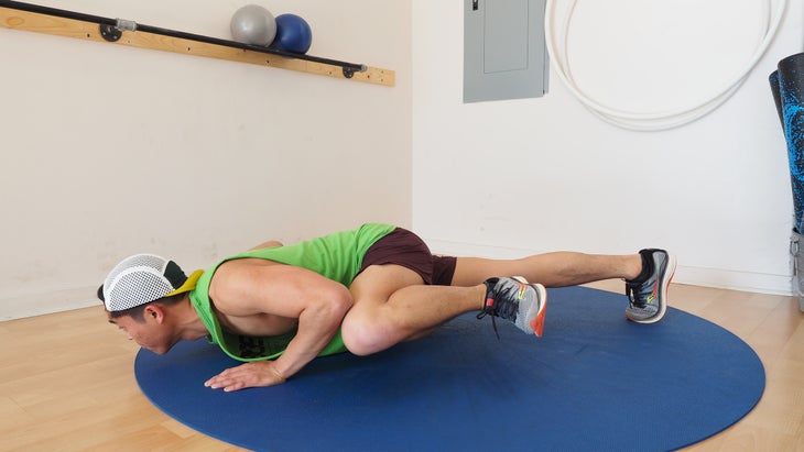 man in low push-up touching left knee to left elbow