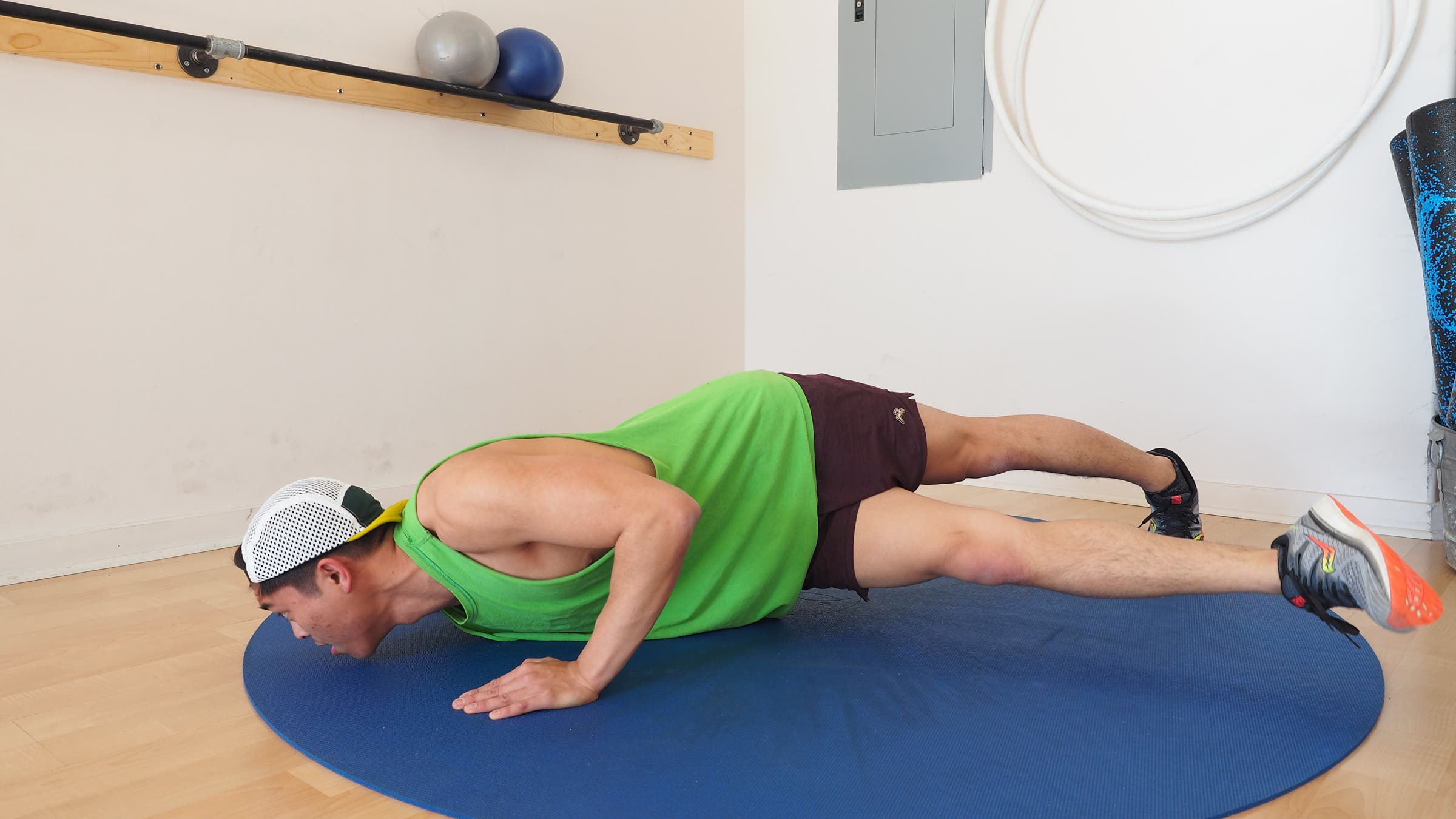 man at bottom of push-up swinging right leg under him and toward the left side
