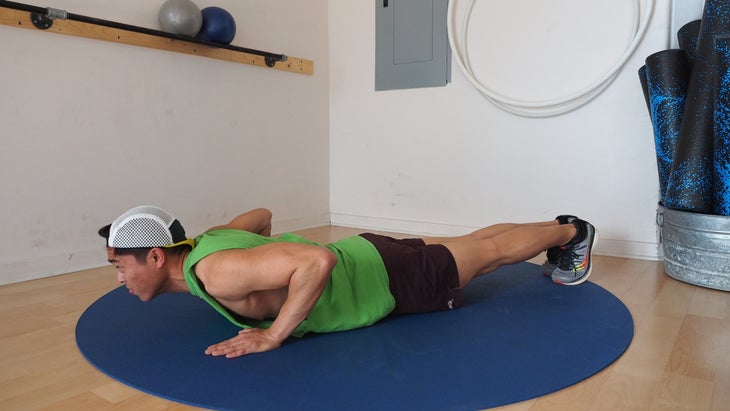 man in green shirt at bottom of push-up