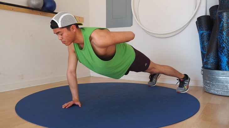 man in high plank with left arm behind his back