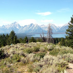A hiker viewing the Grand Tetons and Jackson Lake in Wyoming.