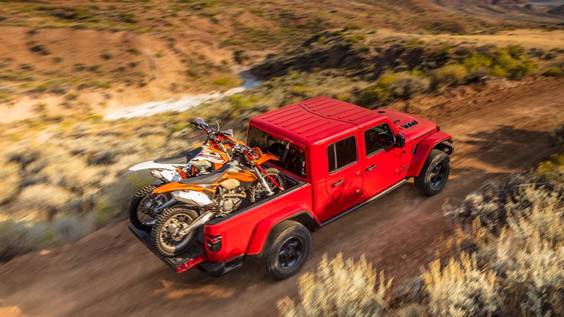 The bed is specifically designed to accommodate two full-size dirt bikes side by side, with a large gear bag between them.