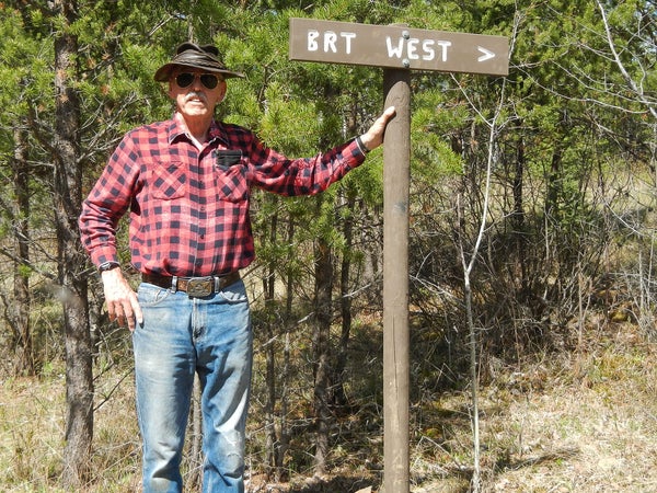 John Elliot near a trail marker for the Border Route Trail he works to maintain.