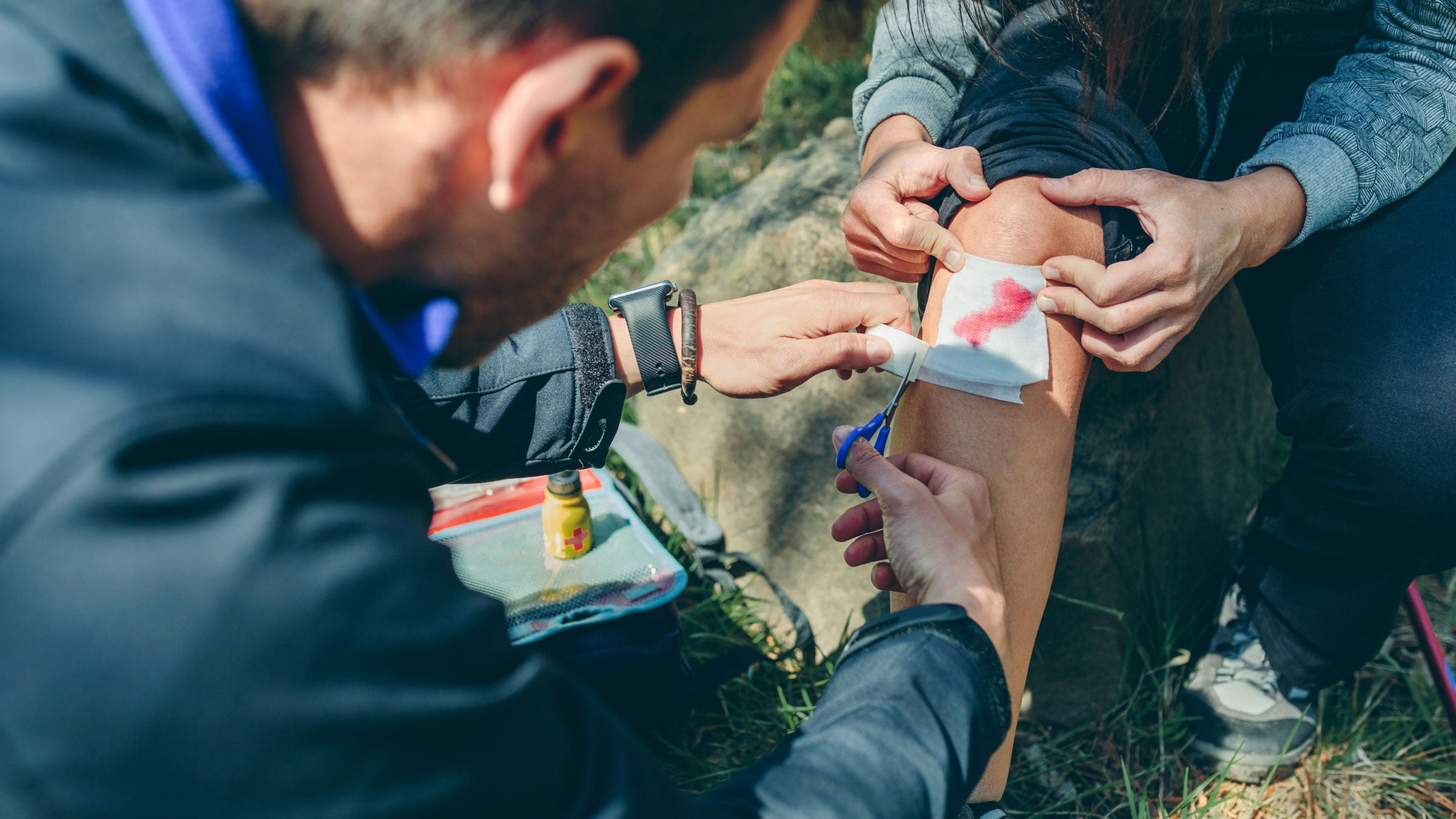 medic treating and stitching a wound
