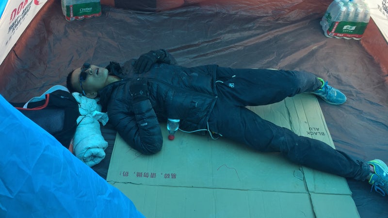 Liang Jing, the Ultra Gobi's 2018 champion, takes a rest at the race's high point, at over 13,000 feet.