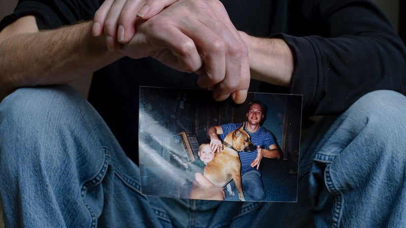 Friede holds up one of the two photos he keeps on his fridge: an image his wife snapped with his dog and 6-year-old son just after Friede was bitten by for the first time by an Egyptian cobra.