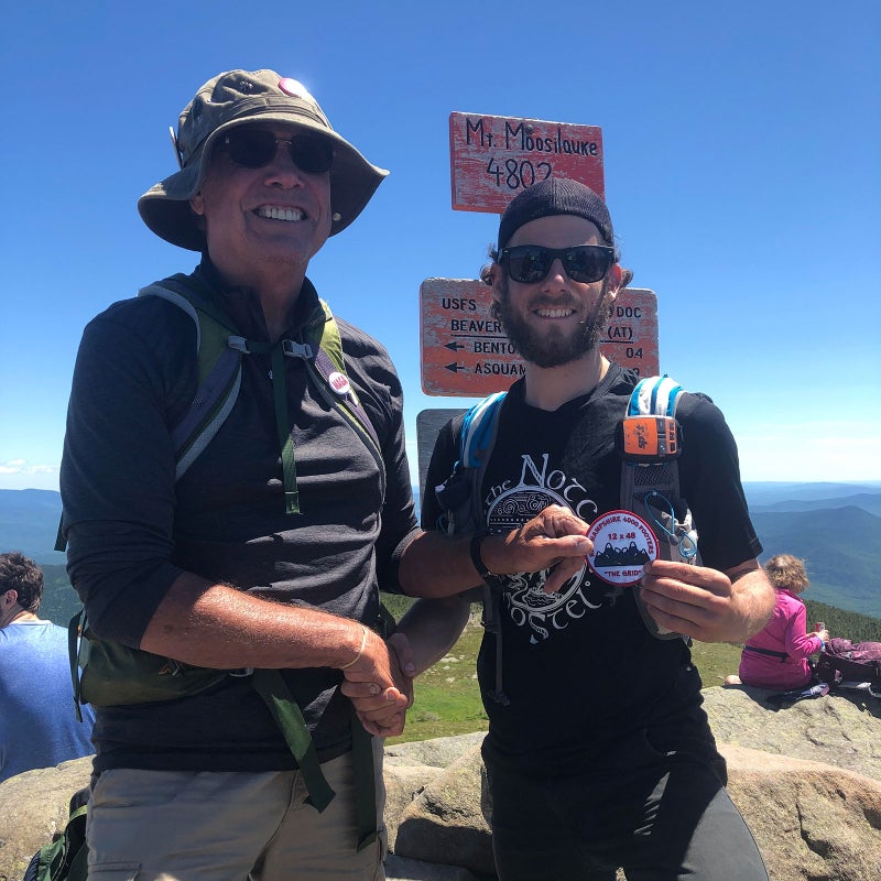 Ed Hawkins, who operates the White Mountains 4,000-footers grid website and tracks those who finish it, presents Carcia with a patch in honor of his completion.