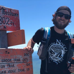 Philip Carcia soaks in the moment as he summits Mount Moosilauke, his 576th and final peak of the single-year grid.