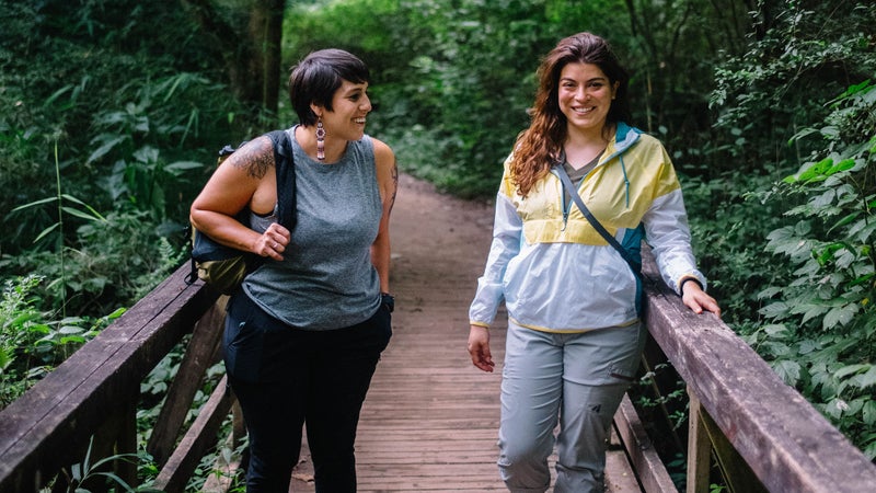 Adriana (left) in Eddie Bauer Resolution Tank Top and Guide Pro Pants with a Stowaway Packable Sling Bag. Luz (right) in Eddie Bauer Momentum Light Jacket and Guide Pro Capris.
