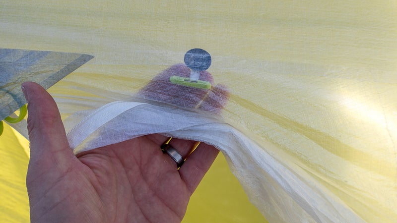 The fly fabric is 0.34-ounce-per-square-yard Dyneema composite fabric (DCF). It looks delicate, and in this case it is. But heavier versions of DCF are stronger and more waterproof than standard shelter nylons while still being lighter weight.