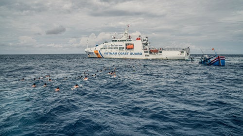 Dozens of Vietnamese detainees escape an Indonesian patrol ship and swim toward a Vietnamese coast-guard ship.