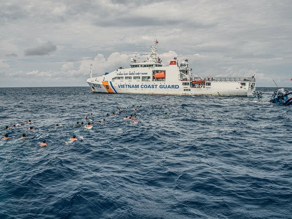 Dozens of Vietnamese detainees escape an Indonesian patrol ship and swim toward a Vietnamese coast-guard ship.
