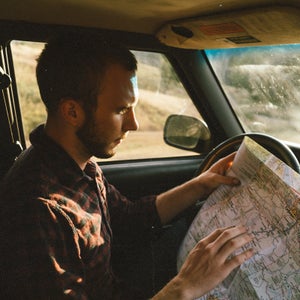Man sitting in a car looking at a map