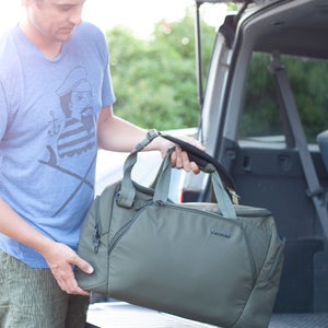 Man putting a duffel bag into the trunk