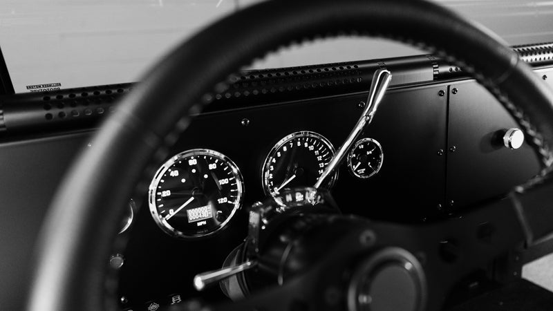 The dash has no screens and no buttons, just analog dials and manual switches. The HVAC vents run through the perforated tubes mounted under the windscreen. Rotate those towards you, or the windshield, depending on your needs.