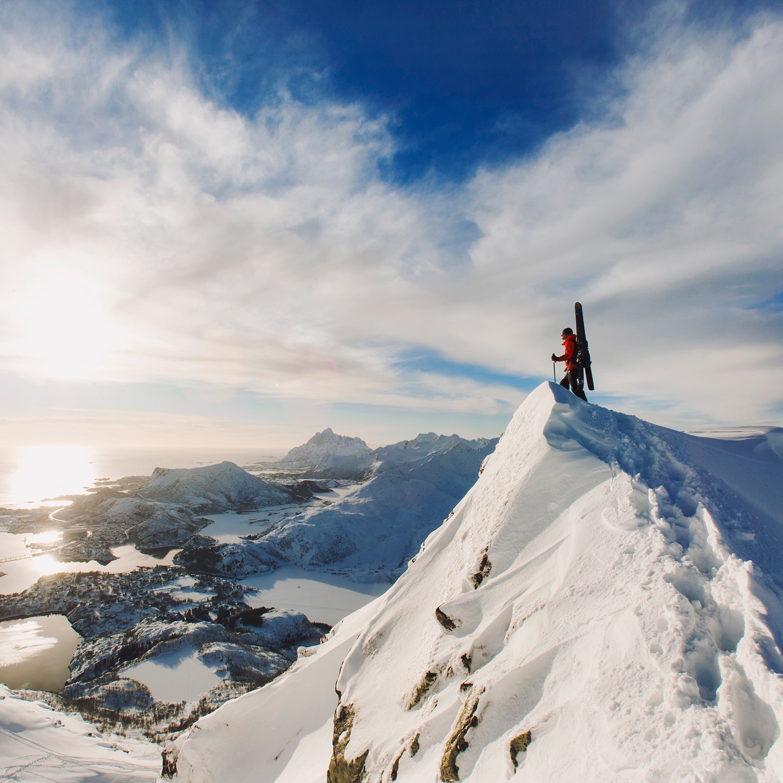 Skier standing atop snowy peak