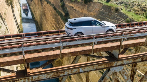 The Evoque crosses a railroad bridge over a canal in Greece.