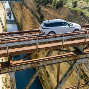 The Evoque crosses a railroad bridge over a canal in Greece.