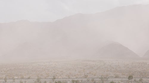 Vehicles Parked At Parking Lot Against Mountains At Death Valley During Sandstorm