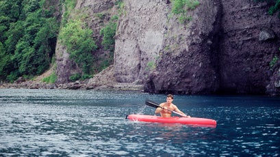 A adventure tourist enjoys kayaking in Dominica's  Scotts Head Marine Reserve. Soufriere, Dominica , Eastern Caribbean.