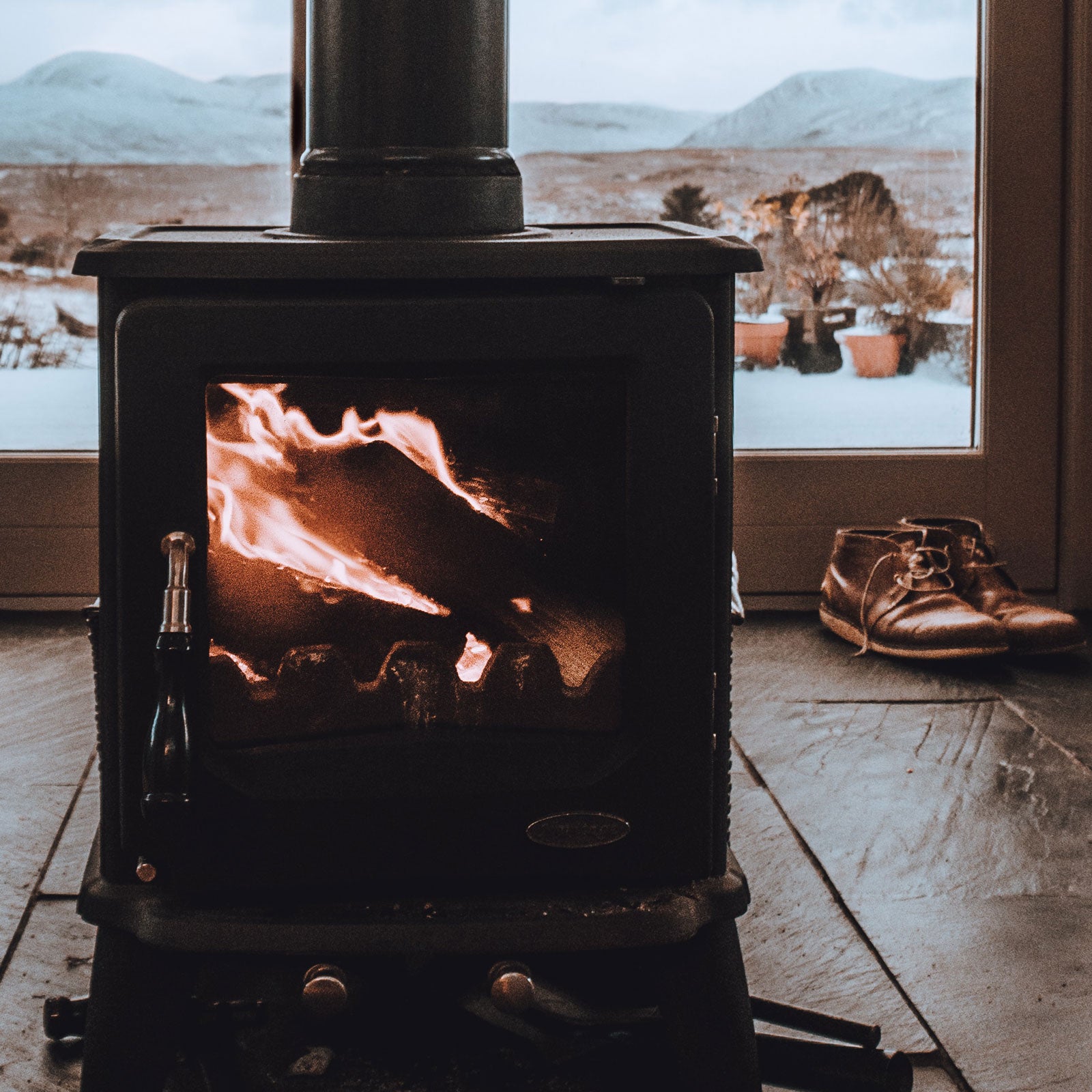 Wood burning fireplace in snowy cabin