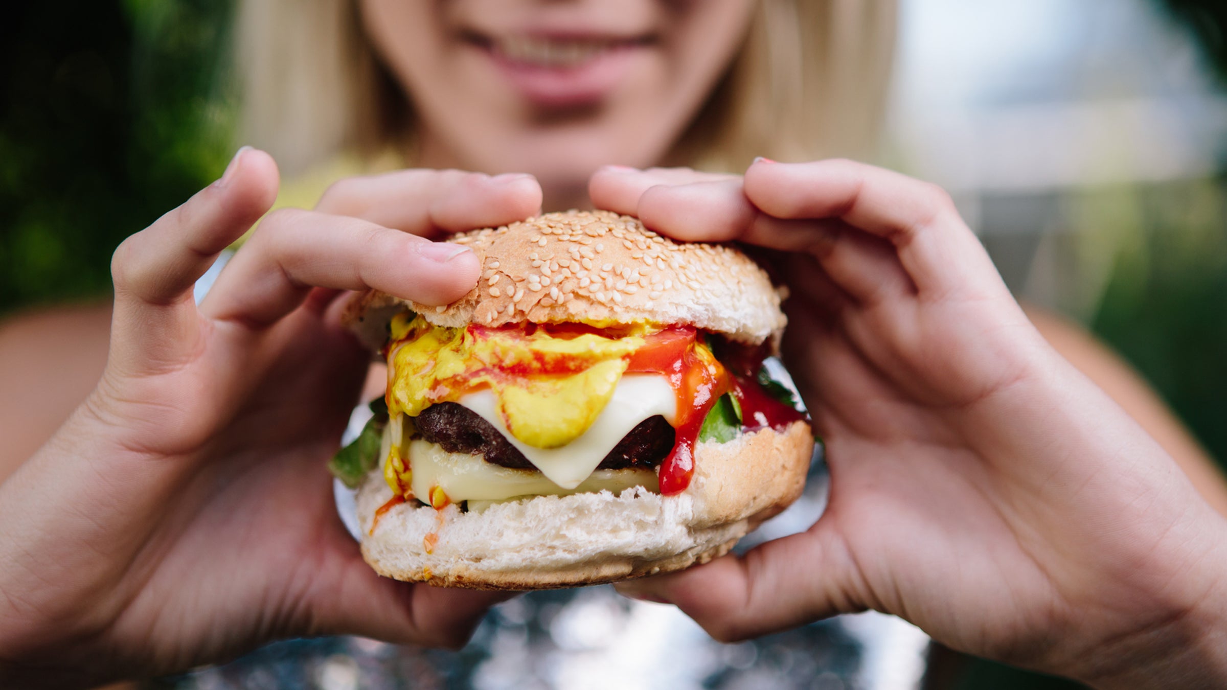 Woman Preparing To Eat A Large Cheese Burger