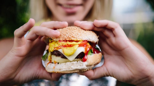 Woman Preparing To Eat A Large Cheese Burger
