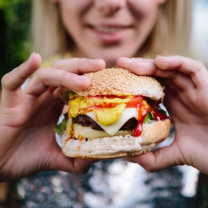 Woman Preparing To Eat A Large Cheese Burger