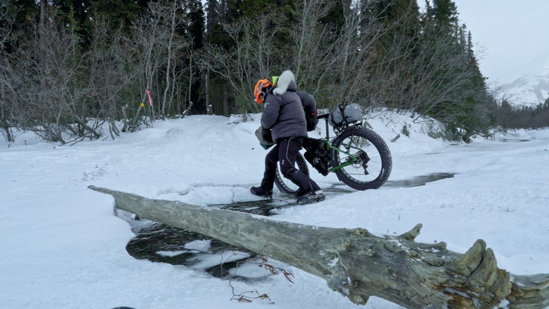 A rider navigates an open-water crossing on her way to the Rohn checkpoint in the Alaska Range.