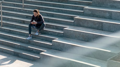 Woman Sitting On Stairs Having A Break From Jogging