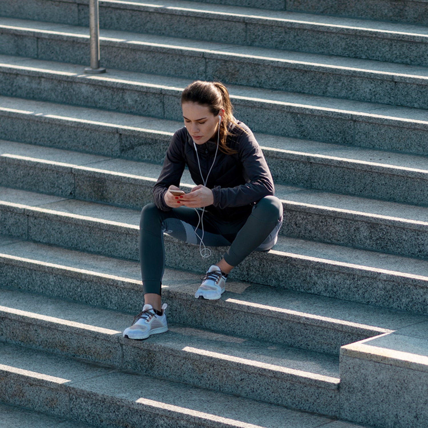 Woman Sitting On Stairs Having A Break From Jogging