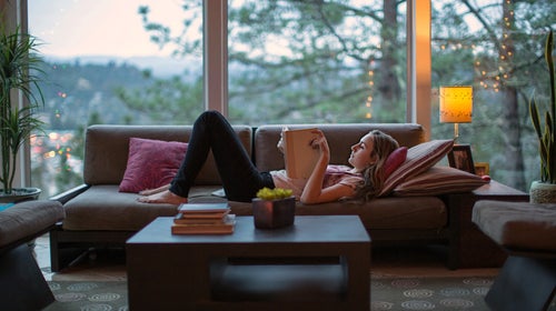 Teenage Girl Reading On The Couch In A Modern Home