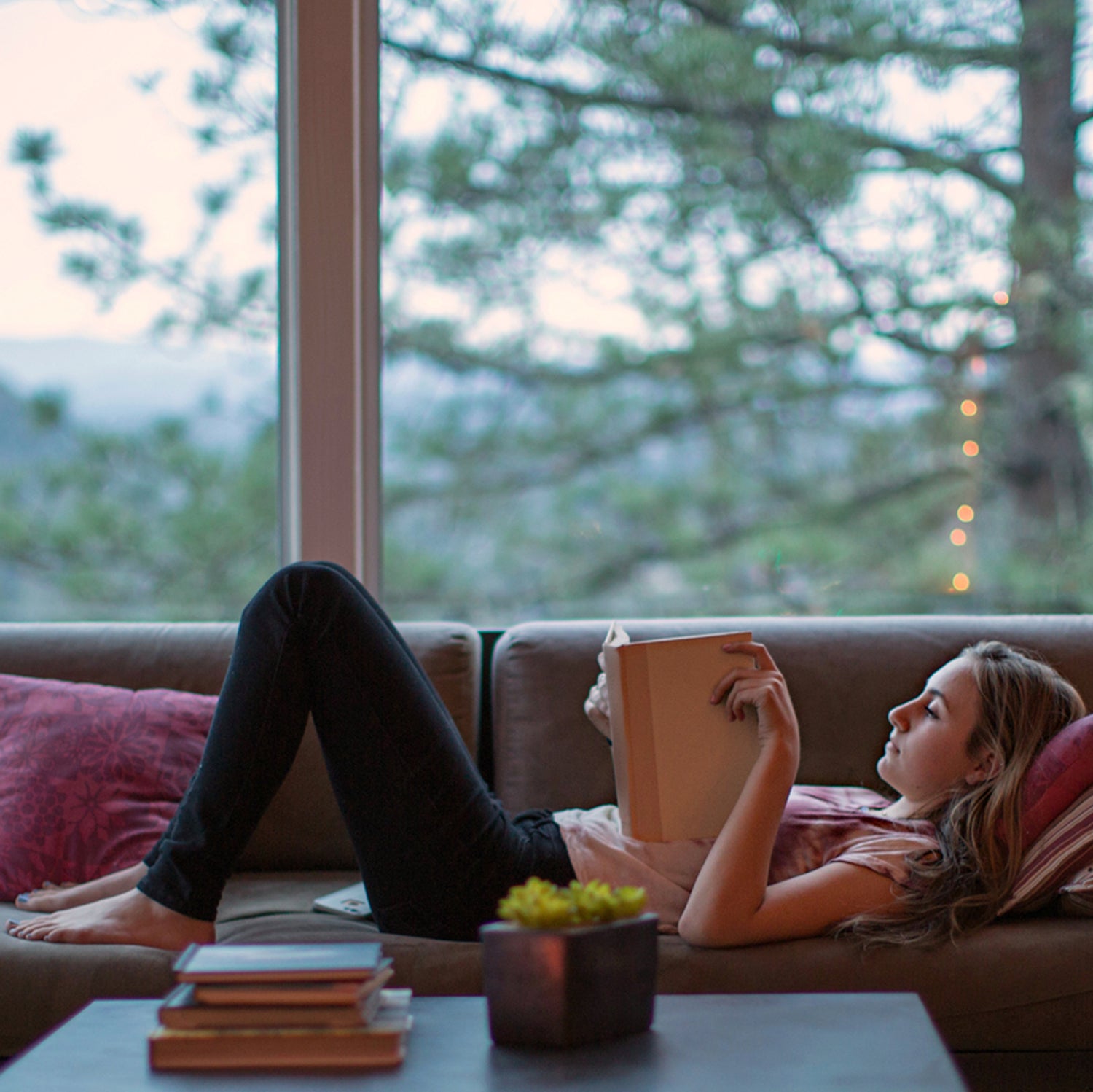 Teenage Girl Reading On The Couch In A Modern Home