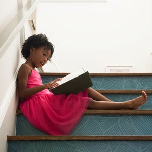 Girl Reading Book In Staircase