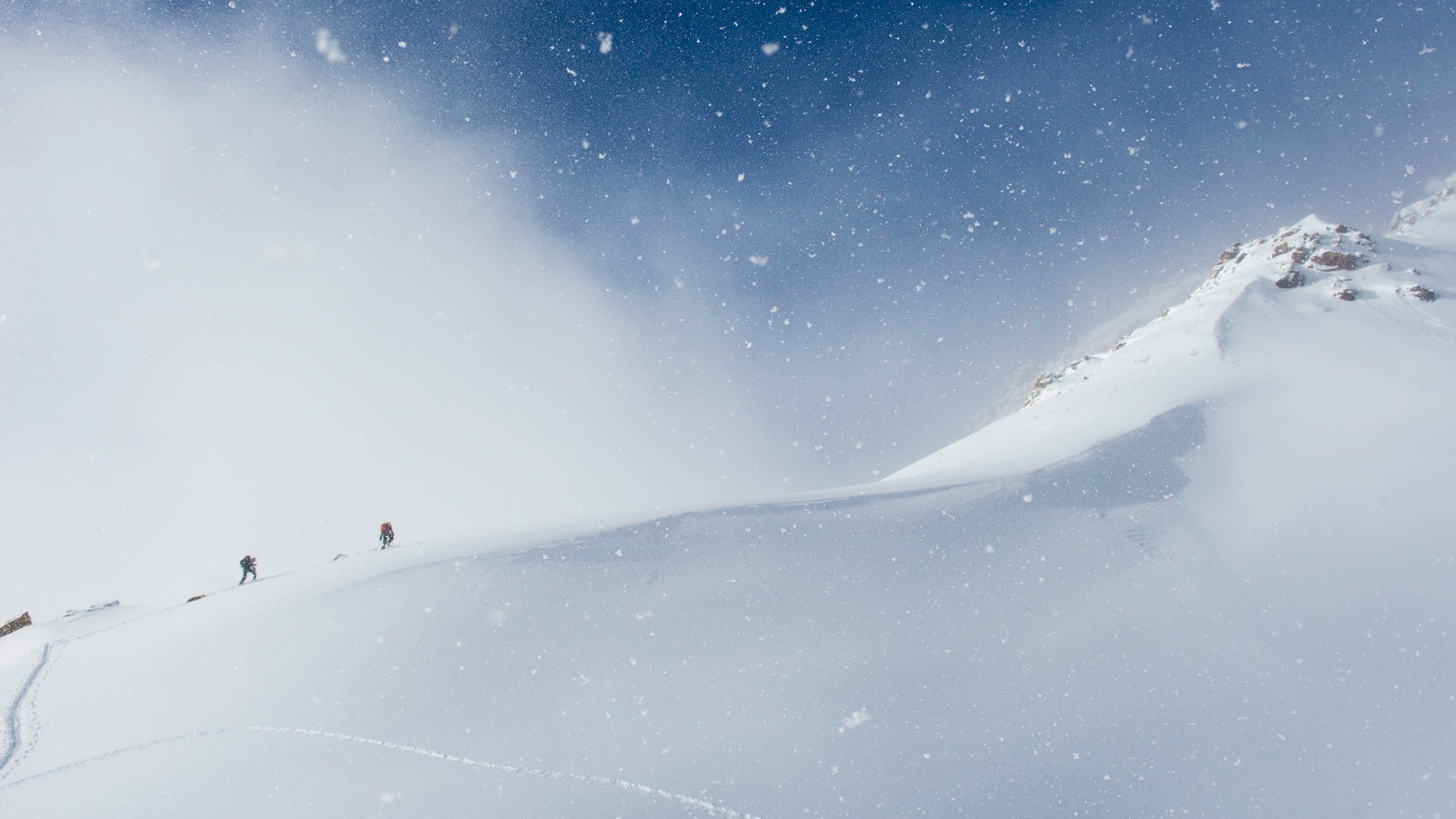 A man and woman backcountry skiing above Ophir Pass, San Juan National Forest, Silverton, Colorado.