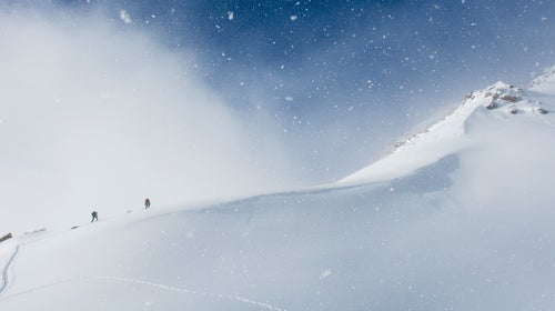 A man and woman backcountry skiing above Ophir Pass, San Juan National Forest, Silverton, Colorado.