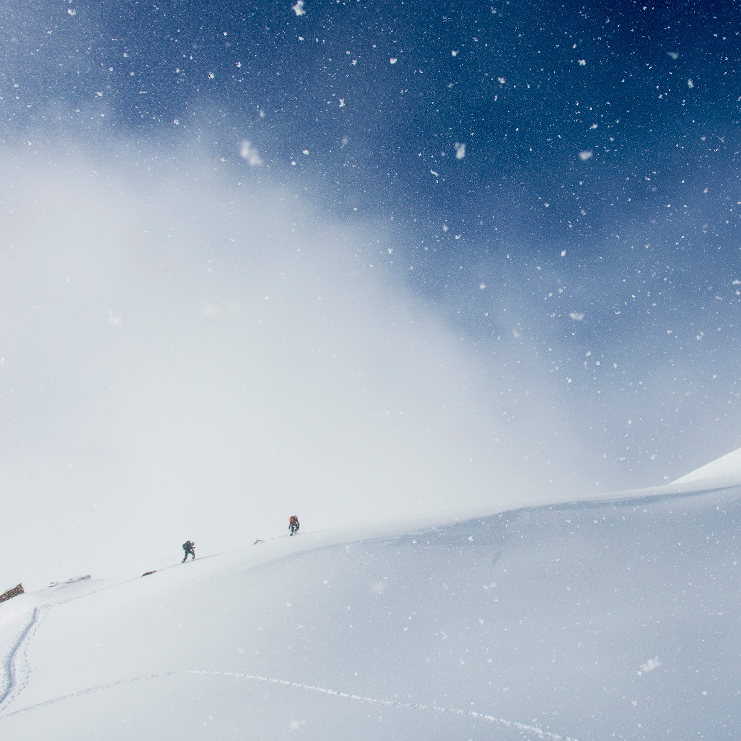 A man and woman backcountry skiing above Ophir Pass, San Juan National Forest, Silverton, Colorado.