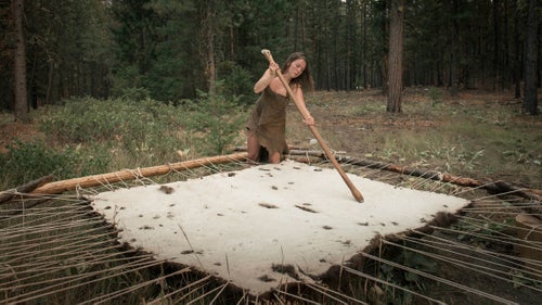 A student softens a bison hide on Lynx’s property in Twisp before the backcountry segment of the 2014 project. The resulting tanned hide will provide an insulating layer that she can cover her entire body with when out in the wild.