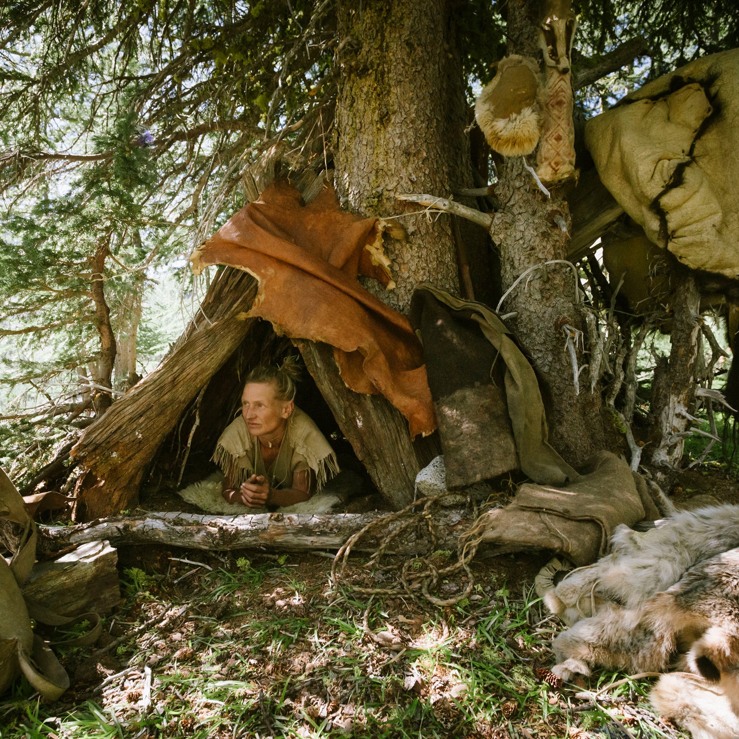 Lynx Vilden in a bark shelter she built in Washington’s North Cascades