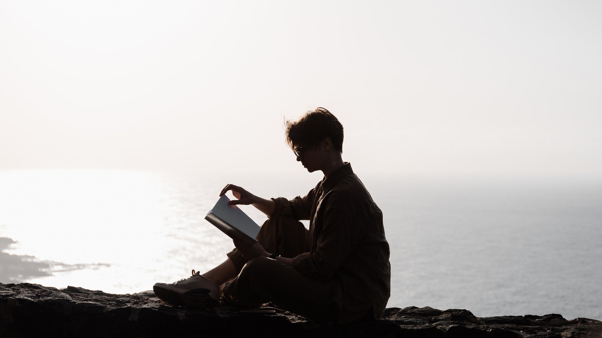 Woman Sitting On High Mountains Hills And Reading.