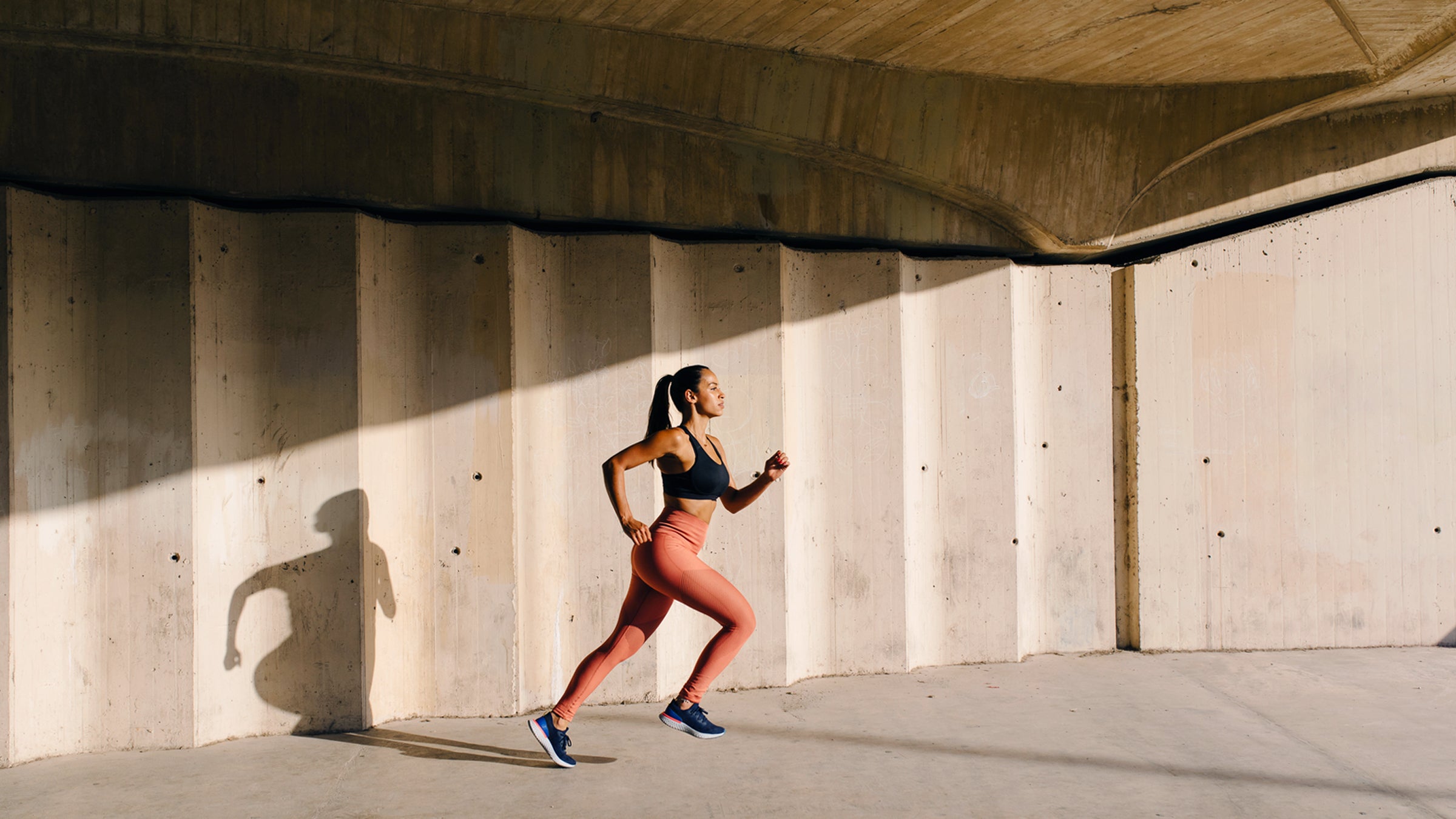 Athletic Woman Running On Street In Sunlight